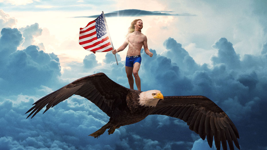 A man in underwear holding a U.S. flag and riding on a bald eagle